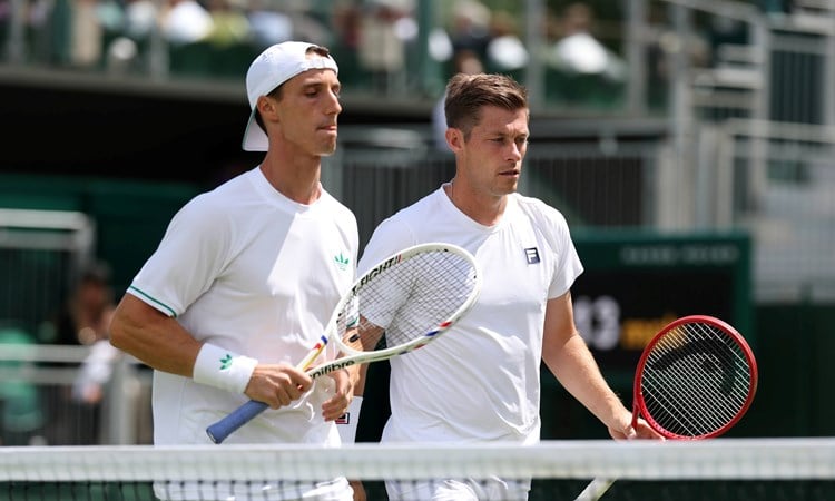 Joe Salisbury and Neal Skupkski walk towards the net with their rackets in hand