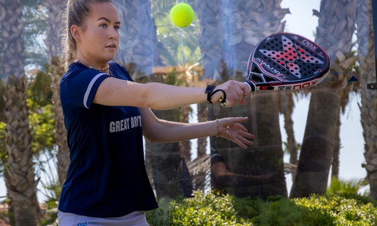 Tia Norton connecting with the ball with a backhand slice 