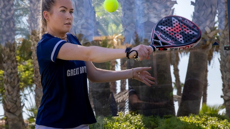 Tia Norton connecting with the ball with a backhand slice 