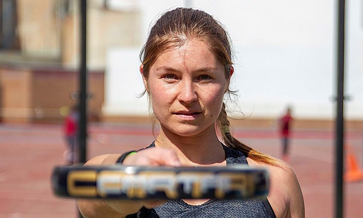 Hansie Ruddick pointing at the camera with her Padel racquet