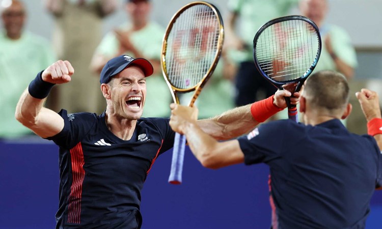 Andy Murray screaming and cheering alongside Dan Evans while holding their tennis rackets