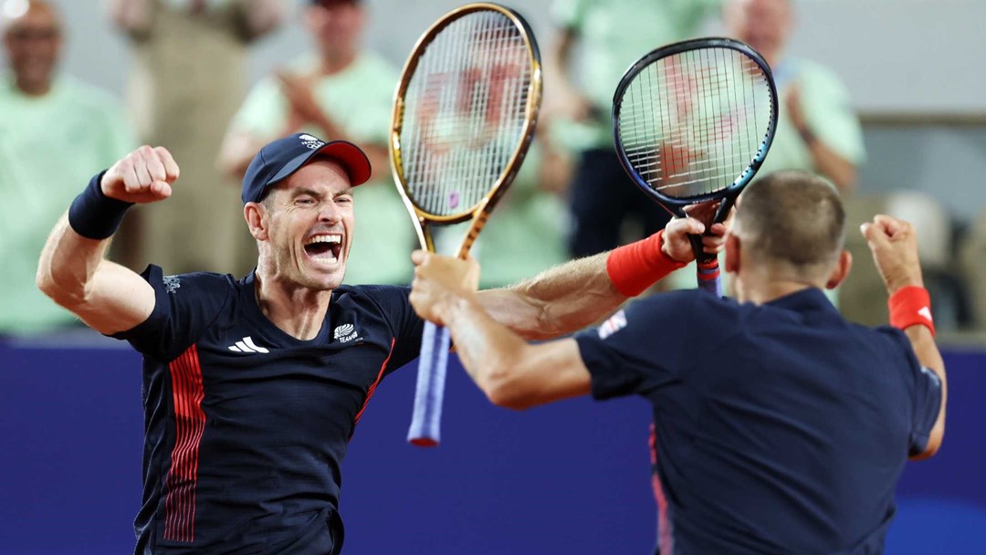Andy Murray screaming and cheering alongside Dan Evans while holding their tennis rackets