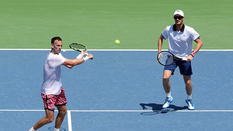 Michael Venus hitting a backhand slice at the net while Jamie Murray stands further back on court at the Western and Southern Open final