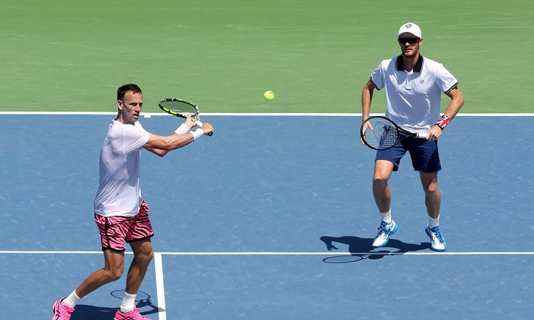 Michael Venus hitting a backhand slice at the net while Jamie Murray stands further back on court at the Western and Southern Open final