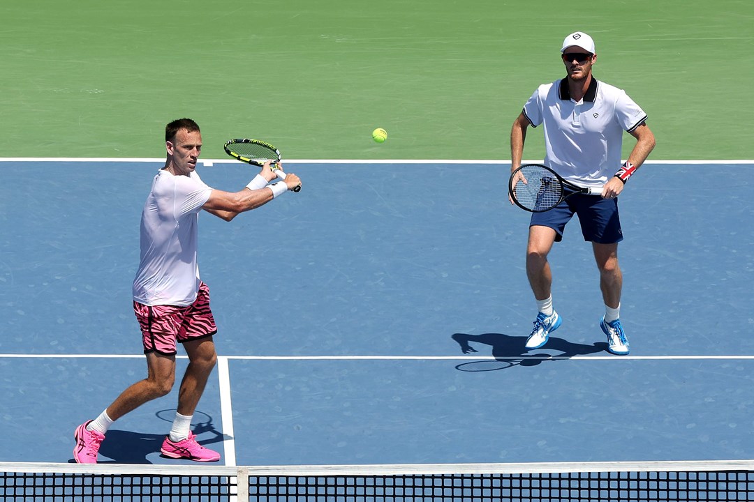 Michael Venus hitting a backhand slice at the net while Jamie Murray stands further back on court at the Western and Southern Open final