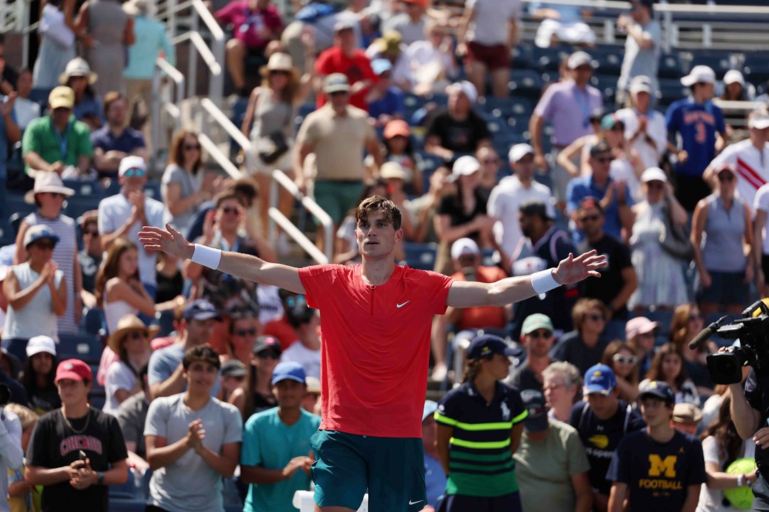 Jack Draper stood on court at the US Open with his hands out wide in celebration