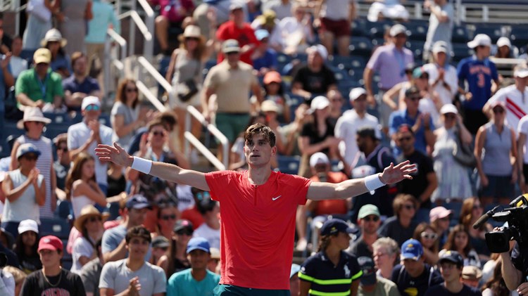 Jack Draper stood on court at the US Open with his hands out wide in celebration