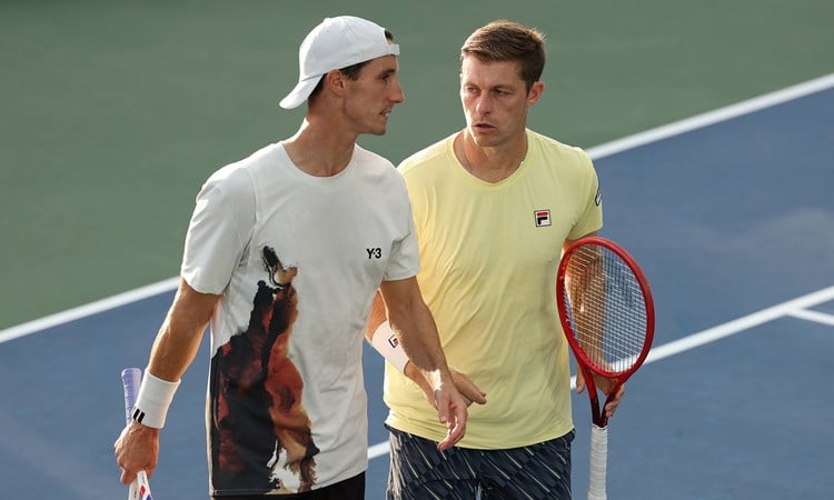 Joe Salisbury and Neal Skupski talking on court during their third round win at the 2025 US Open