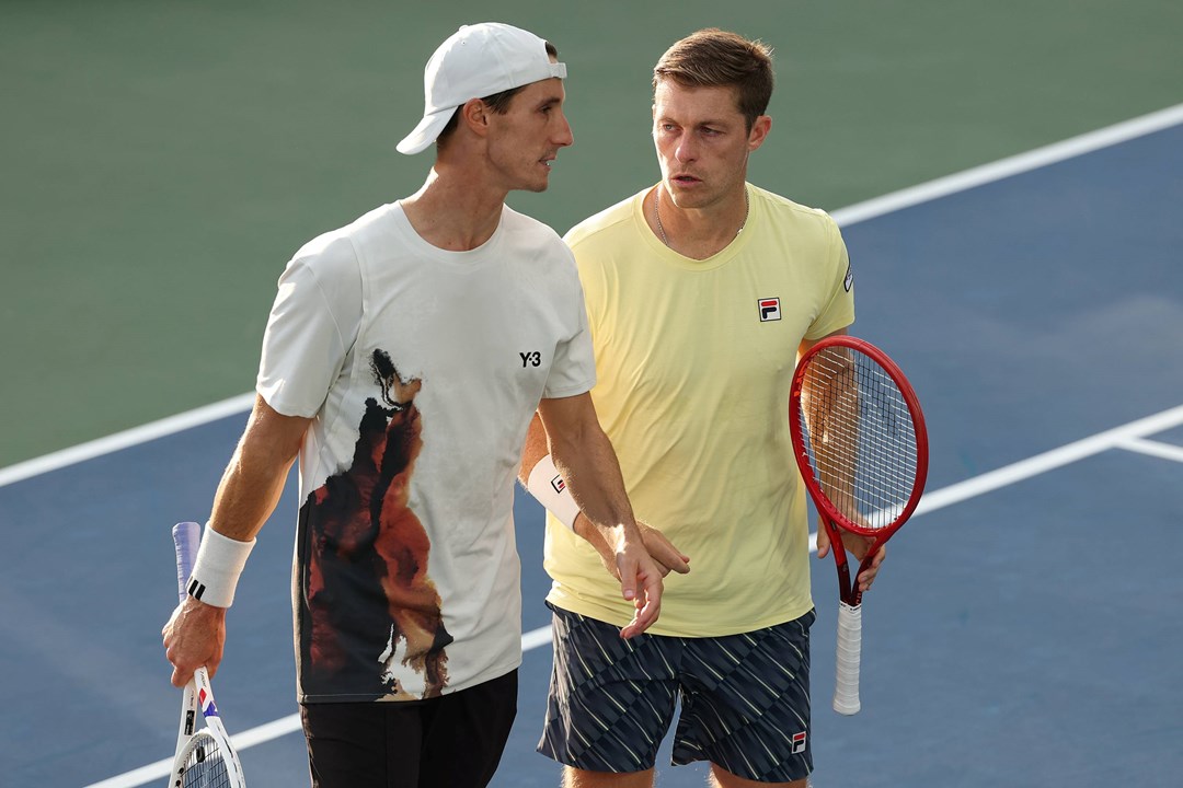 Joe Salisbury and Neal Skupski talking on court during their third round win at the 2025 US Open