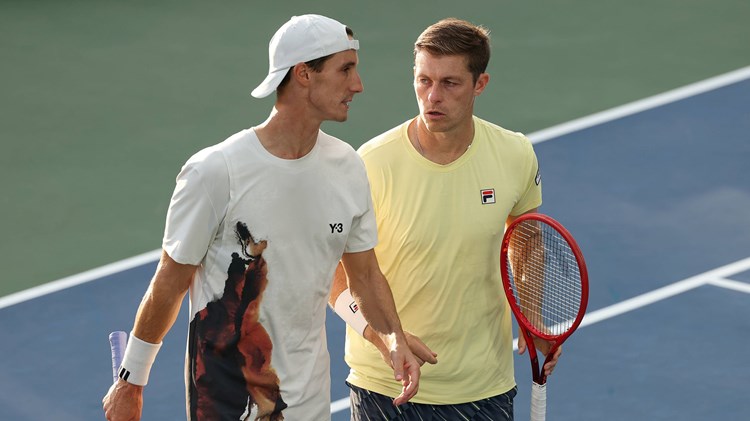 Joe Salisbury and Neal Skupski talking on court during their third round win at the 2025 US Open