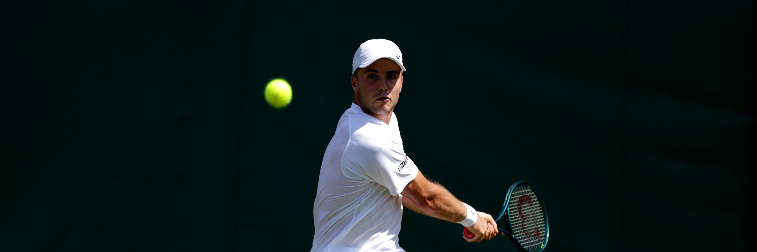 Arthur Fery hitting a backhand on court at Wimbledon