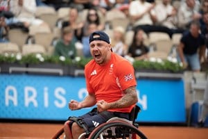 Wheelchair tennis star Andy Lapthorne clenching his fists in celebration after winning his first match at the Paralympics