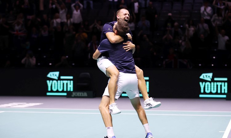Dan Evans and Neal Skupski hug after clinching the doubles decider at the Davis Cup against France