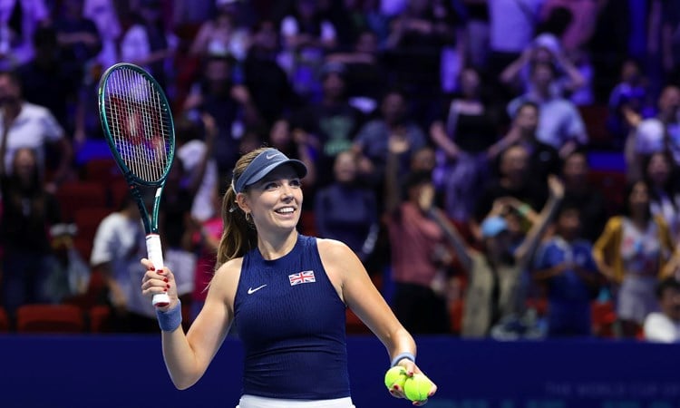 British tennis player Katie Boulter smiling while holding her racket in the air at the Billie Jean King Cup Finals in Shenzhen