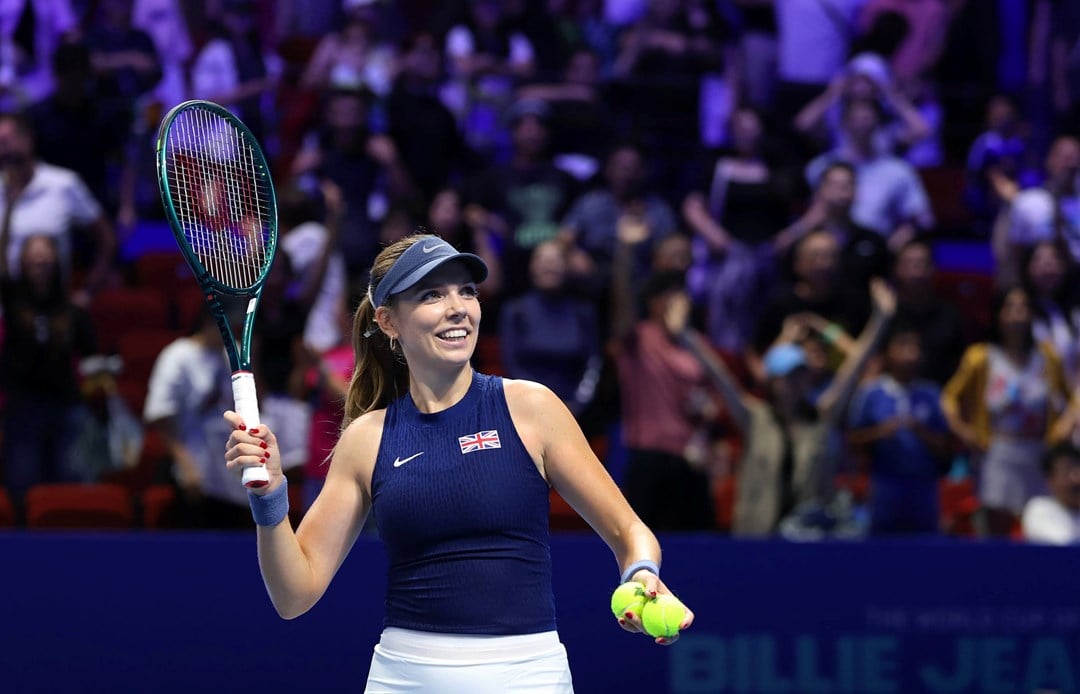 British tennis player Katie Boulter smiling while holding her racket in the air at the Billie Jean King Cup Finals in Shenzhen