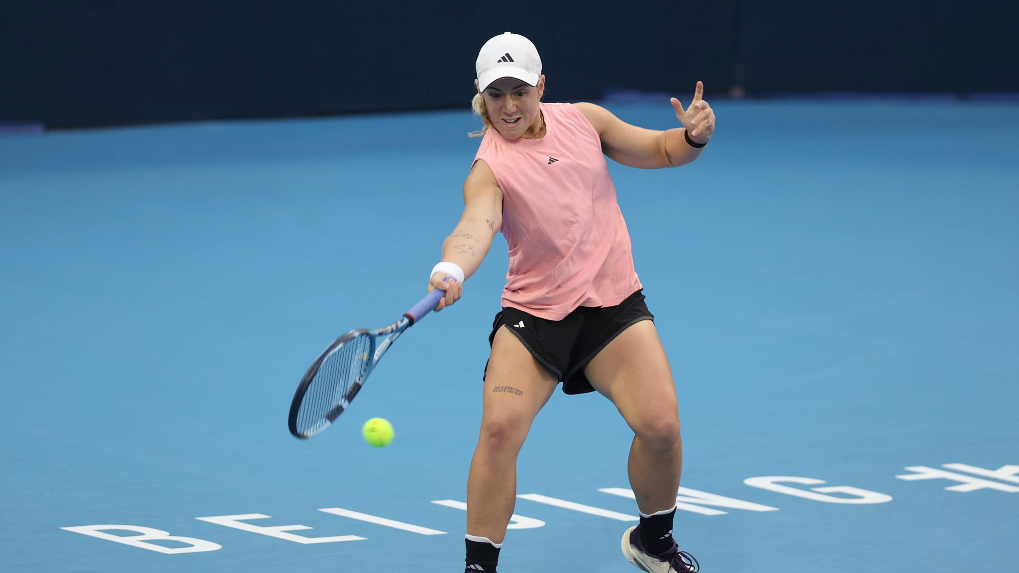 British tennis player Sonay Kartal bending down low to hit a forehand on court at the China Open