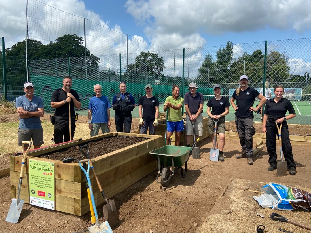 Totnes Community Tennis Club players and local police force helping build the community garden