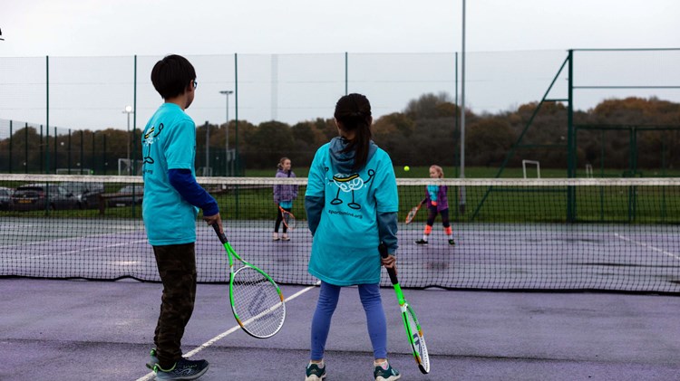Young people taking part in a Sport In Mind tennis session on park courts