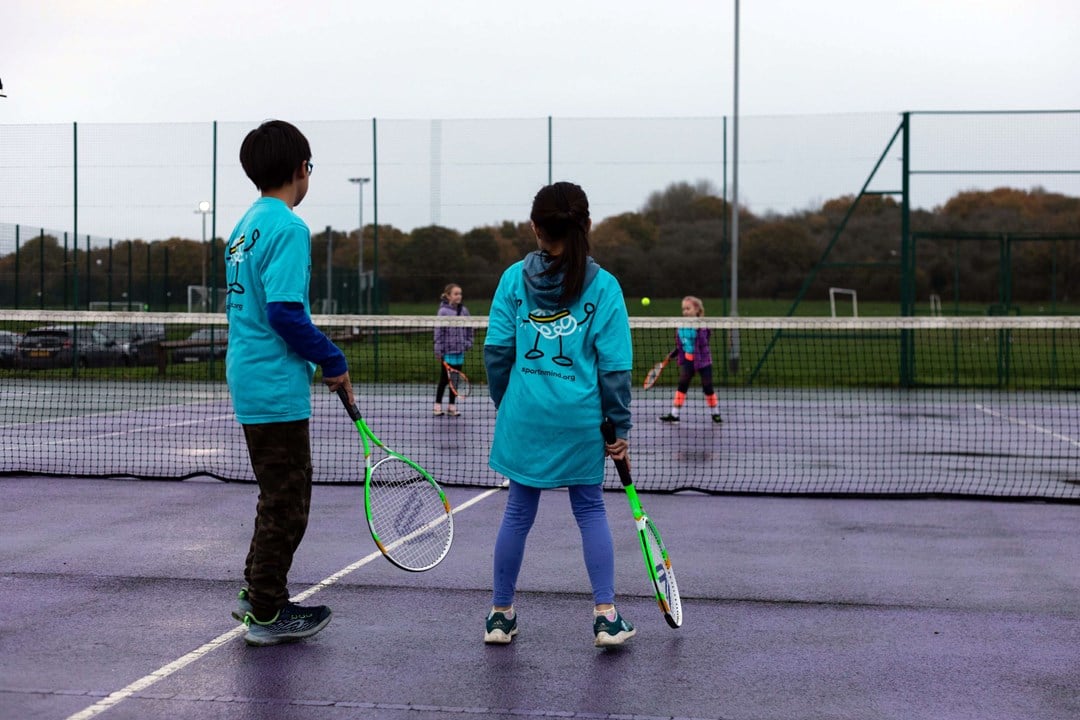Young people taking part in a Sport In Mind tennis session on park courts