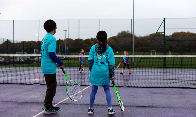 Young people taking part in a Sport In Mind tennis session on park courts