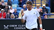 British tennis player Billy Harris clenching his fist and holding his tennis racket on court 