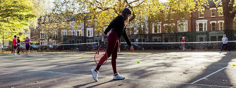 Woman playing tennis in a park