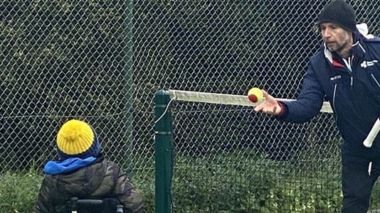 Mark Bullock throwing a tennis ball during a coaching session