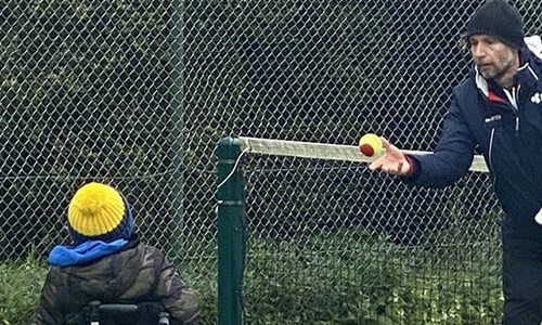 Mark Bullock throwing a tennis ball during a coaching session