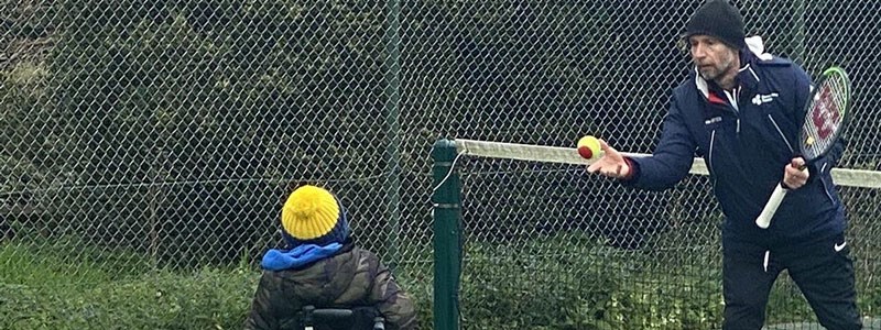 Mark Bullock throwing a tennis ball during a coaching session