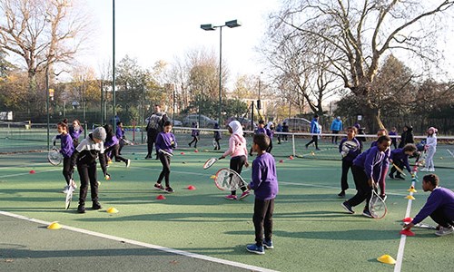 kids taking part in a community tennis session on park tennis courts