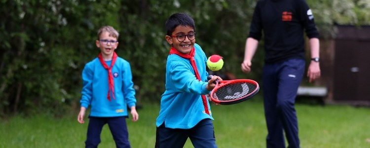 Two boys playing tennis with the Scouts