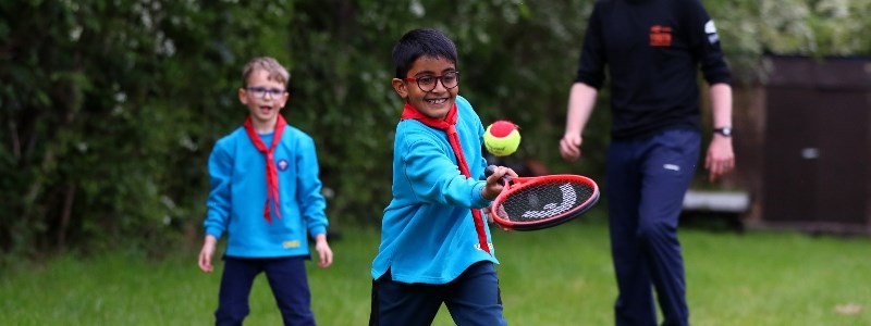 Two boys playing tennis with the Scouts