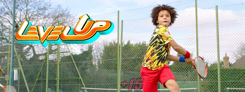 Child playing tennis with level up logo in picture