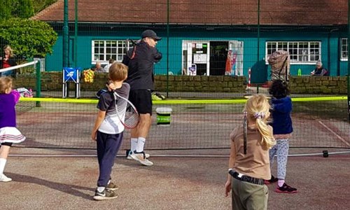 A coach and children as part of the Leeds community tennis programme