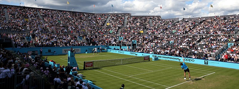 Player serves on Centre court at the Fever Tree Championships at The Queen's Club