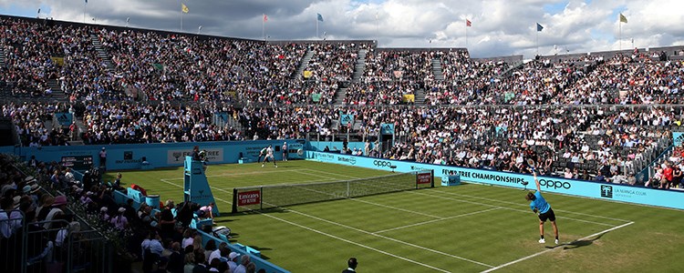 Player serves on Centre court at the Fever Tree Championships at The Queen's Club