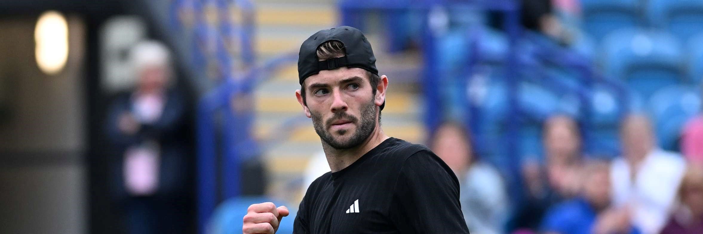 British tennis player Jacob Fearnley holding his tennis racket in one hand and clenching his fist in the other at the Lexus Eastbourne Open