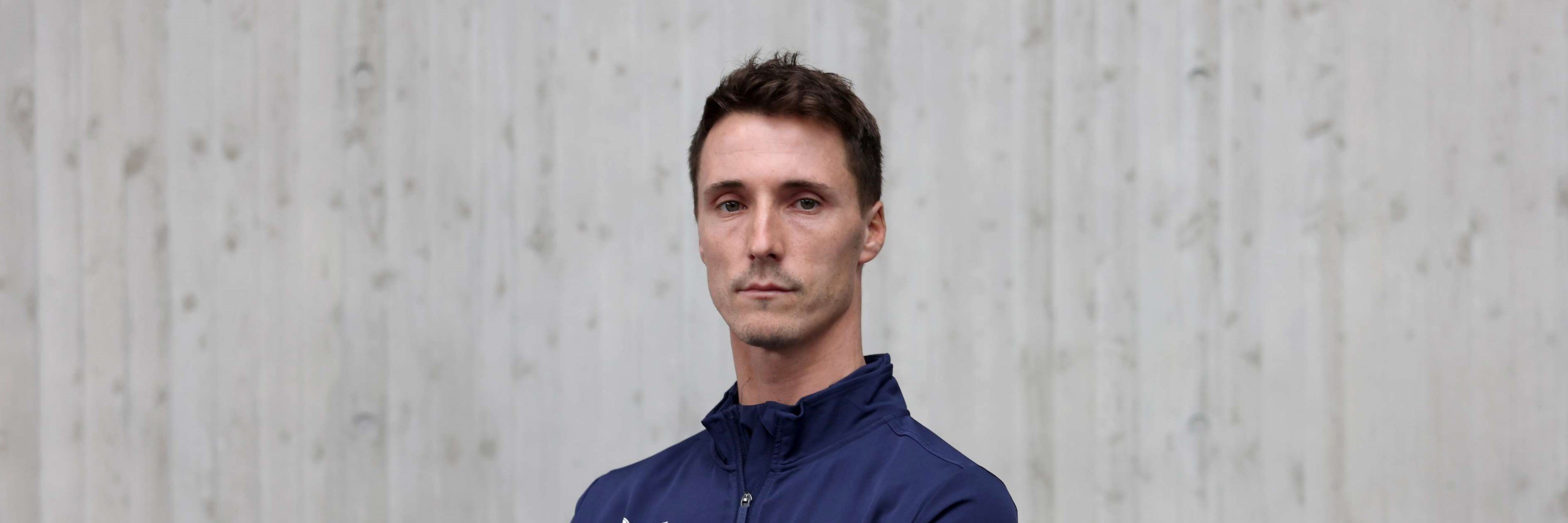 British tennis player Joe Salisbury crossing his arms over his chest in his Lexus GB Davis Cup team kit