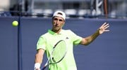 British doubles player Joe Salisbury holding his racket out in front of him to hit a backhand slice on court at the Lexus Eastbourne Open