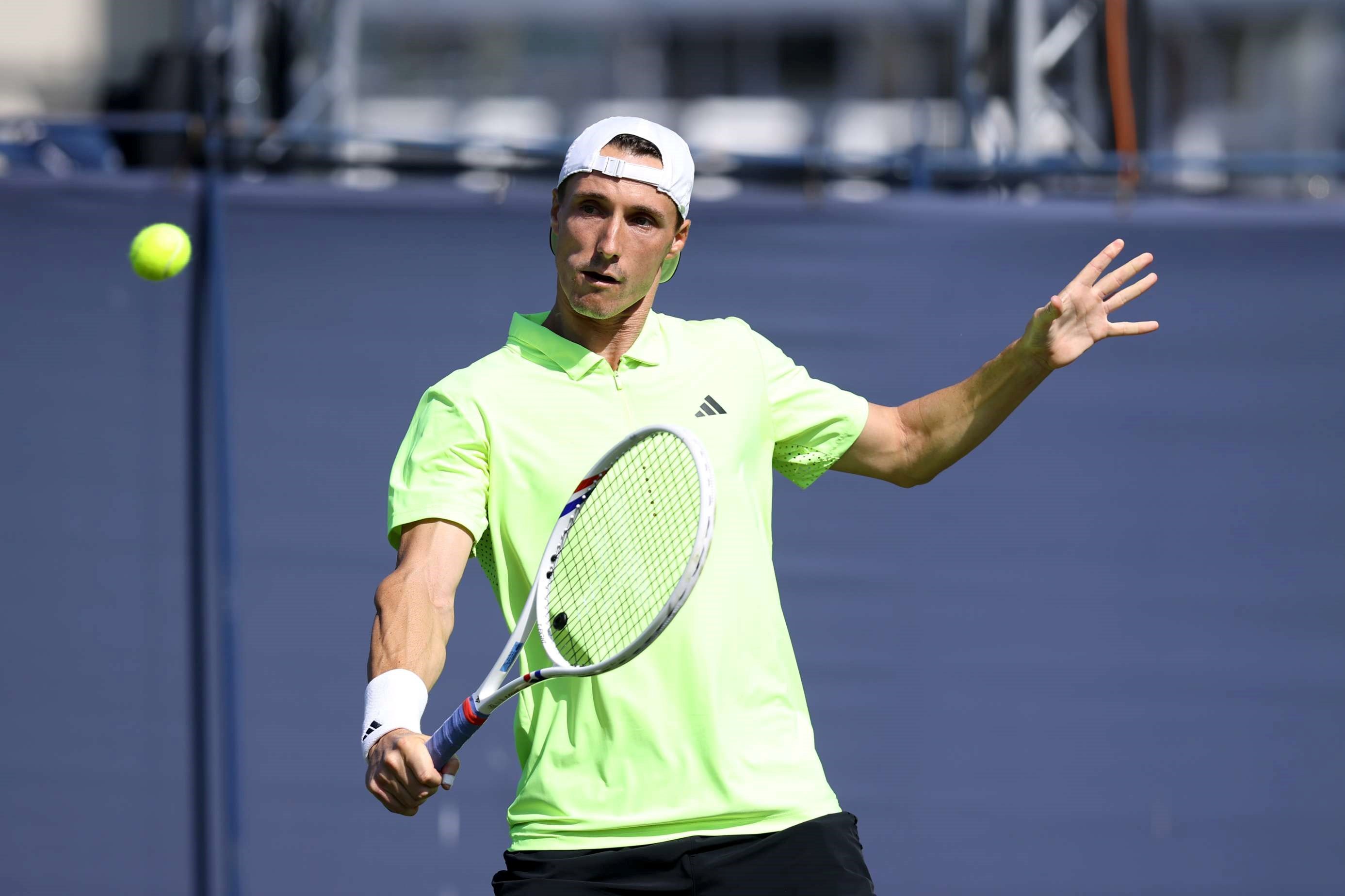 British doubles player Joe Salisbury holding his racket out in front of him to hit a backhand slice on court at the Lexus Eastbourne Open