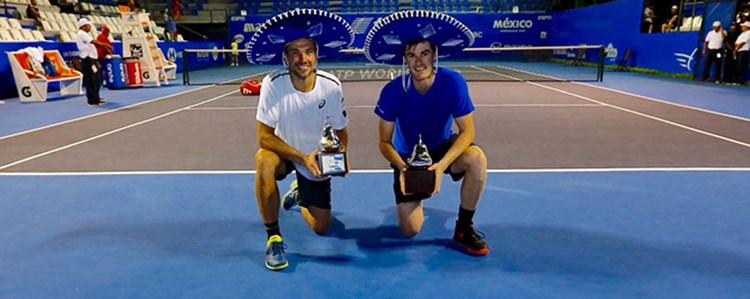 Jami Murray and Bruno Soares kneeling with their awards in hand on a tennis court