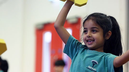 Young girl taking part in a tennis session in a primary school