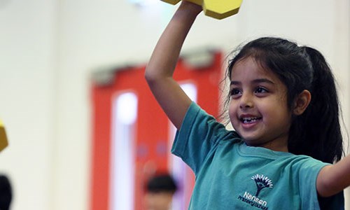 Young girl taking part in a tennis session in a primary school