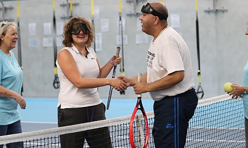 Two visually impaired players shake hands at the net