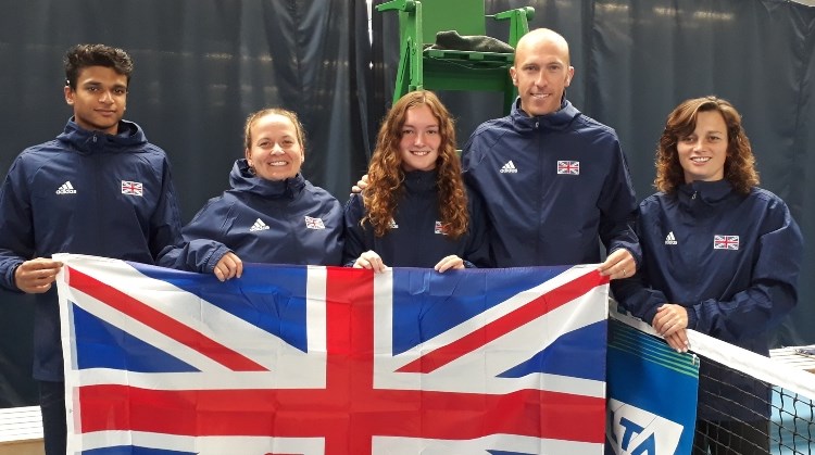 The Great Britain Deaf Tennis Squad holding the Union Jack flag on a tennis court
