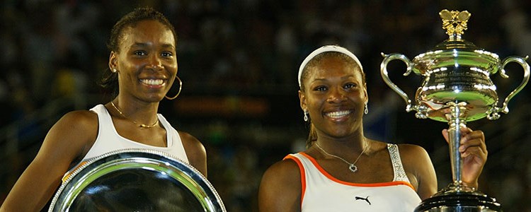 Serena and Venus Williams smiling with their trophies