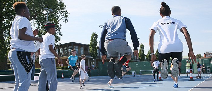 Tennis court full with children playing together