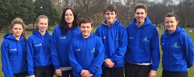 Group of people in matching blue hoodies in an open field