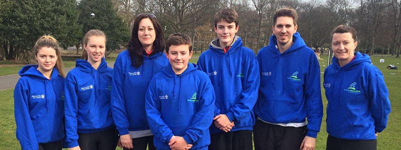 Group of people in matching blue hoodies in an open field