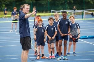 Coach leading school tennis session